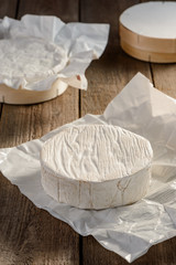 Camembert cheese wheel on a rustic wooden table