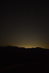 Cielo nocturno con montañas en alto contraste..