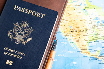 The foil-stamped dark blue front cover of an American passport set on a world map background.