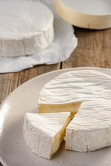 Tasting of a French Camembert cheese. Freshly cut piece
