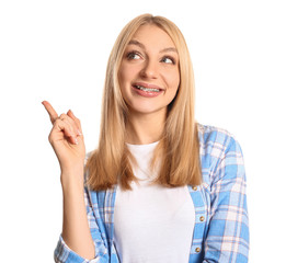 Young woman with dental braces showing something on white background