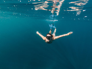Fototapeta na wymiar Young woman snorkeling in sea