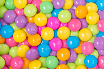Pile of colorful sweet candy chocolates coated on white paper. colourful collection background.