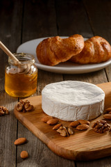 Nuts, honey and Brie cheese on a rustic wooden table