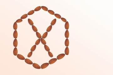 Letter X of the English alphabet from nuts in hexagon shape. Food pattern made from nuts alphabet for shop and diet