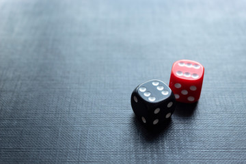 Closeup to a red and black dices in double six pair over a black background. Ideal fo gamble, board games and bets