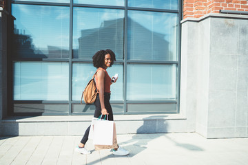 African American woman walking with bags
