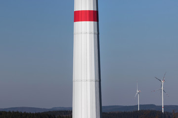 modern wind turbine column in front of the evening sun