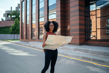 Black student In campus and studying map while looking at camera
