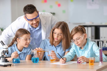 Obraz na płótnie Canvas Teacher conducting chemistry lesson in classroom
