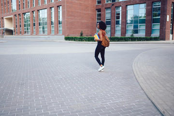 Fototapeta na wymiar Young slim black lady walking in street