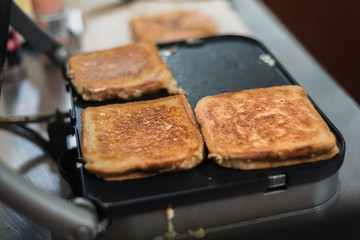 teenager making toasted sandwiches