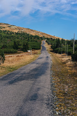 Asphalt road in the mountain landscape of Krkonose National Park, Czech Republic. Path from Vyrovka to Lucni bouda in autumn. Popular hiking destination in Krkonose mountains (Giant mountains).