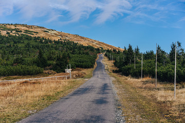Asphalt road in the mountain landscape of Krkonose National Park, Czech Republic. Path from Vyrovka to Lucni bouda in autumn. Popular hiking destination in Krkonose mountains (Giant mountains).