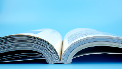 Close up book pages flipping on blue background..
