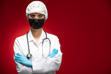 Woman of doctor with face mask looking at camera on red background, corona virus concept.