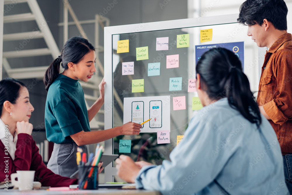 Aufkleber asian ux developer and ui designer presenting mobile app interface design on whiteboard in meeting at modern office.Creative digital development mobile app agency