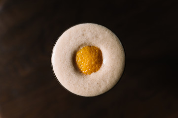 Espresso martini cocktail decorated with slice of orange zest. Top view.