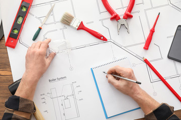 Male builder working with house plan, top view