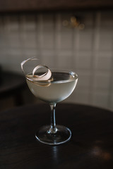 Glass of cocktail based on gin, birch juice cordial and essential oil of frankincense, decorated with a piece of birch bark. Smooth image with shallow depth of field.