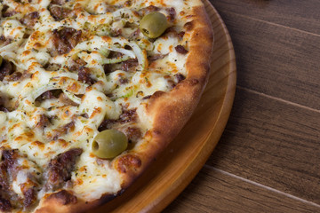 Meat pizza on wooden board. Made with Mozzarella, picanha meat, onion, cheese, tomato sauce and olives. Filet Steak, meat.Left alignment.