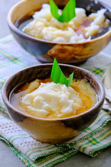 Bubur Sumsum. Javanese dessert porridge of rice flour, coconut milk with palm sugar syrup. Served in an wooden bowl. A popular starter food for breaking the fast during Ramadan.