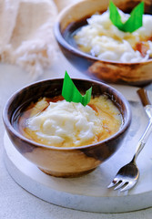 Bubur Sumsum. Javanese dessert porridge of rice flour, coconut milk with palm sugar syrup. Served in an wooden bowl. A popular starter food for breaking the fast during Ramadan.