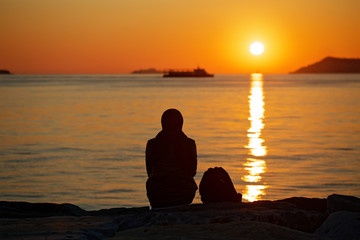 Silhouette of a muslim woman watching the sea of Marmara sunset in Maltepe, Istanbul, Turkey
