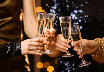 Women clinking glasses of tasty champagne at party