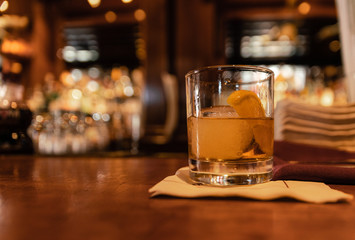 a glass of whiskey on a bar counter