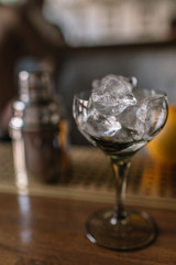 Before making cocktail bartender cooling glass with cubes of ice.