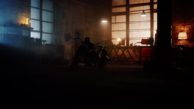Custom Bobber Motorbike Standing in an Authentic Creative Workshop. Motorcycle in Low Key Light Before the Lamps are Turned On and We See the Bike in All Its Glory.