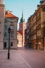 Obraz premium The Royal Castle of Warsaw at the end of a street in the old town of Warsaw