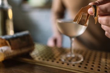 Cocktail based on gin, birch juice cordial and essential oil of frankincense, decorated with a piece of birch bark. Smooth image with shallow depth of field.