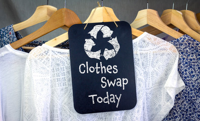Clothes Swap and recycle clothes icon on chalk board with hanging shirts to swap, sustainable...