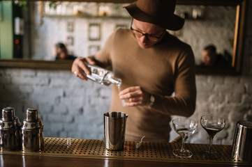 Bartender preparing cocktail based on gin, birch juice and essential oil of frankincense.