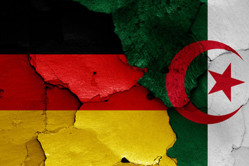 flags of Germany and Algeria painted on cracked wall
