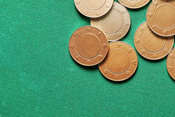 Gold shiny coins heap on the green casino table.  Copy space for your advertisement text. Suit card characters. Dropped chips. Gambling and betting
