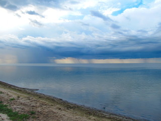 Fototapeta na wymiar Clouds and rain over the smooth surface of the lake. Lake Sivash, Crimean peninsula.