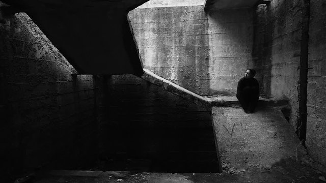 Scared sick person hiding in dark isolation facility.Post apocalyptic life.Mental quarantine concept.Fear,panic,anxiety.Mental health patient.Post apocalyptic life.Feeling alone in destroyed world.&nbsp;