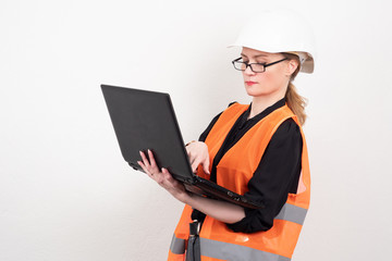 Female engineer. Girl with a laptop in a reflective vest. Girl i