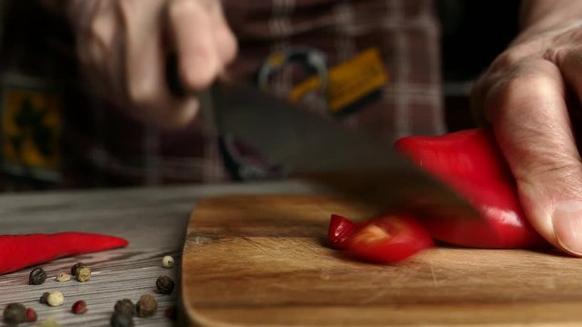 Using Knife To Cutting Ramiro Red Hot Pepper On Cutting Wooden Board. Top View. Panning Slider Shot. Close Up..