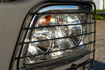 Obraz premium Headlight of a truck with a protective grill