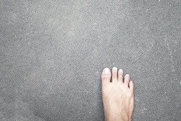 One steep bare foot above pavement