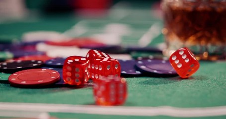 Close up of rolling dice in red on a heap of poker chips shot in 4k super slow motion - Powered by Adobe