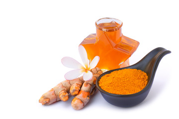 Turmeric ( curcumin, Curcuma longa Linn) root with Tumeric powder in ceramic spoon and glass bottle of extracted essential turmeric oil isolated on white background. Space for text.