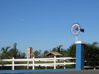 Pinwheel and large tower in the background between wooden fences