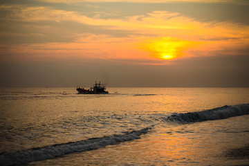 Fototapeta na wymiar Chinese fishing junks plowing the seas at sunset. 
