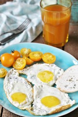 sunny breakfast life style, fried eggs and yellow cherry tomatoes. on a blue plate. yellow and blue