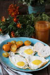 sunny breakfast life style, fried eggs and yellow cherry tomatoes. on a blue plate. yellow and blue